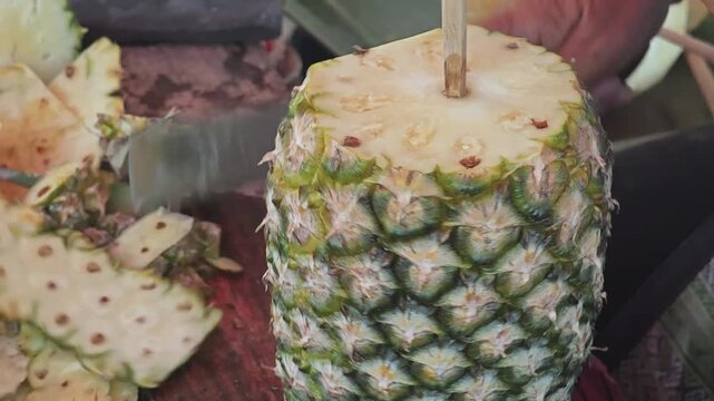 Peeling a pineapple, ready to eat.