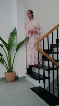 Elegant woman wearing luxury kimono robe in modern tropical home.