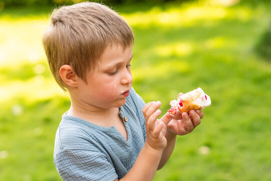 Young Boy Examining Melting Ice Cream Cone Outdoors
