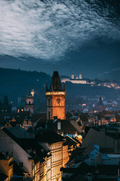 Old Town Hall Tower beneath dramatic clouds at dusk in Prague
