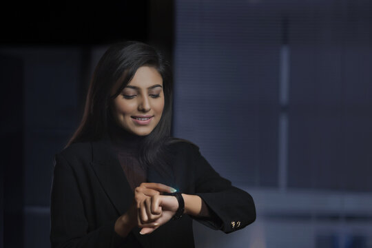 Portrait of young businesswoman checking the time