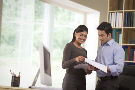 Business colleagues discussing paperwork in office