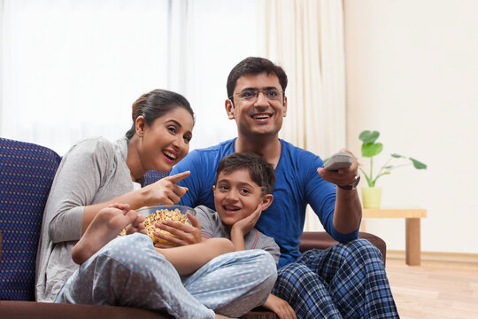Happy family having popcorn while watching TV