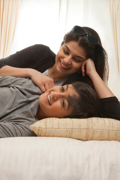 Smiling mother and son relaxing in bed