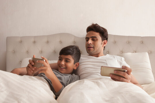 Father and son using smart phone