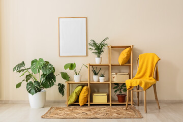 Fototapeta premium Cozy living room interior with a blank picture frame, wooden shelving unit, and various potted houseplants