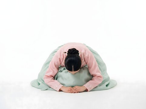 Korean woman bowing in traditional hanbok, sebae New Year greeting pose