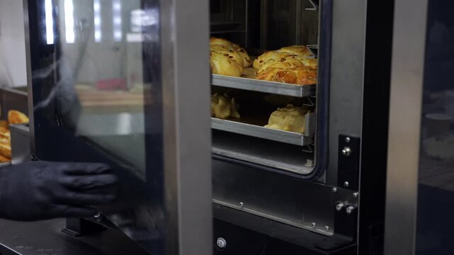 Close-up of a variety of buns with poppy seeds and jam baked in a large industrial oven in the restaurant's kitchen. The concept of catering. Delicious fresh pastries in the dining room.