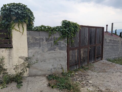 Old entrance gates and a concrete fence at a country property. Weathered, solid, and quietly enduring.

