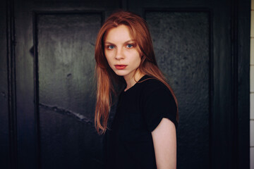 Fototapeta premium Moody Portrait of Beautiful Ginger Woman in Black T-Shirt