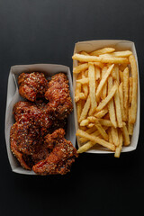 Top view of fried chicken and french fries on black background © Cavan