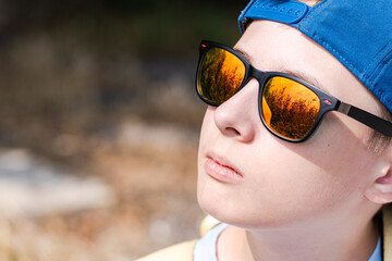 Teenager boy in sun glasses with sky reflection © Cavan