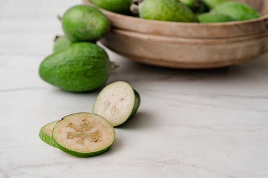 Fresh feijoa fruit sliced on a countertop