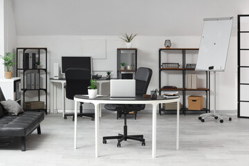 Fototapeta premium Interior of modern office with tables and shelf units
