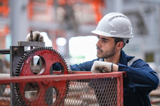 Industrial technician inspects gear assembly, checks machine condition, supports preventive maintenance, equipment inspection, factory operation, engineering process, production safety.