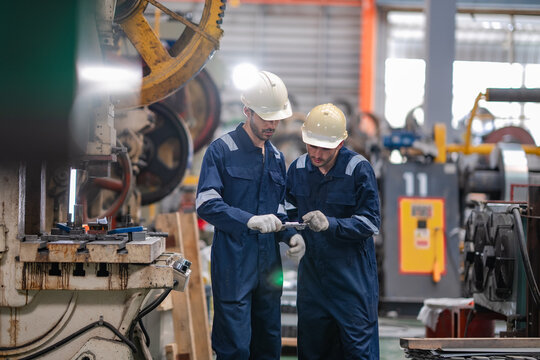 Factory technicians inspect metal component with caliper, check dimensions, support quality control, manufacturing process, engineering inspection, production standards, factory operation.