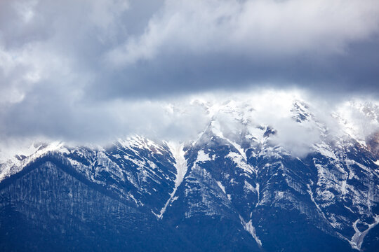 Snow-capped peaks rise beneath heavy, brooding clouds
