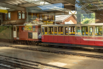 Obraz premium Restored vintage train carriages in a rail depot with maintenance equipment and historic locomotives in Switzerland.