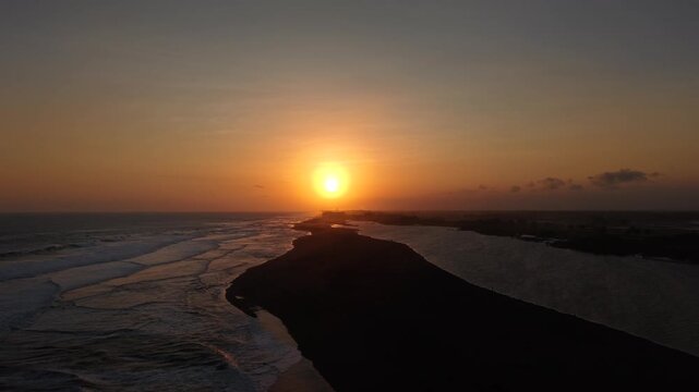 Cinematic opening or closing video. Aerial view of sunset on the edge of the lagoon, savanna and Baros beach, Bantul, Indonesia.