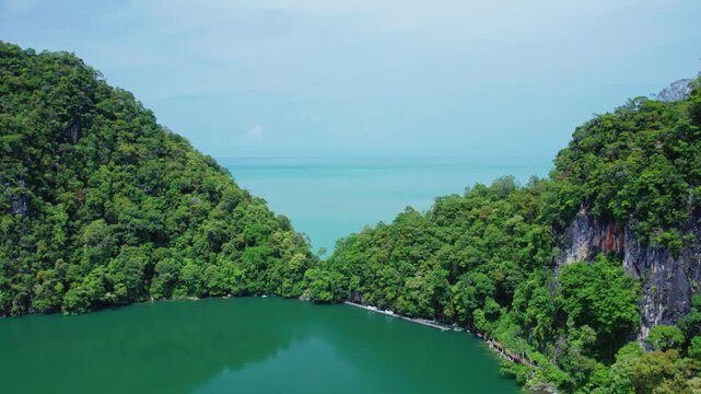 Drone footage capturing the dramatic landscape where Dayang Bunting Lake meets the surrounding rainforest before revealing the breathtaking Andaman Sea beyond.
