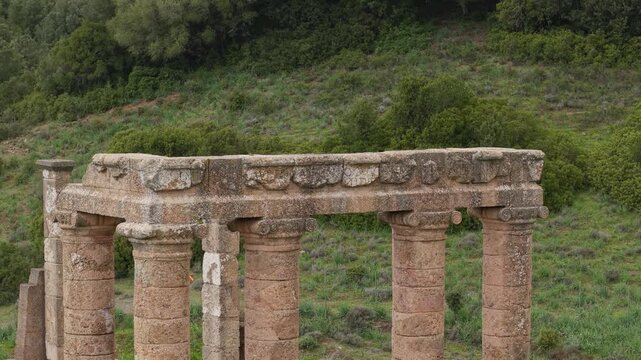 The Ancient Columns Of The Temple of Antas Stand Among The Surrounding Landscape In Sardinia, Italy. Aerial Close-up Shot