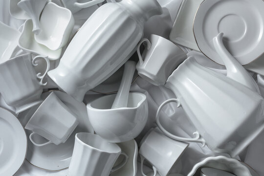 Various white ceramic kitchenware on white fabric.