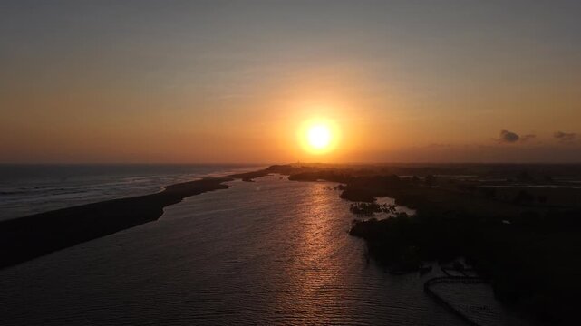 Cinematic opening or closing video. Aerial view of sunset on the edge of the lagoon, savanna and Baros beach, Bantul, Indonesia.