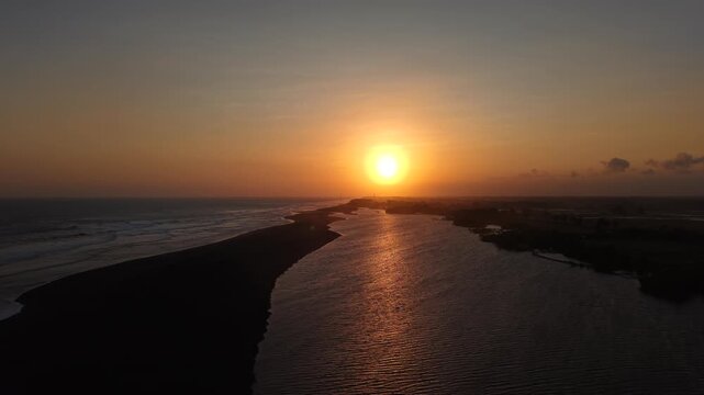 Cinematic opening or closing video. Aerial view of sunset on the edge of the lagoon, savanna and Baros beach, Bantul, Indonesia.