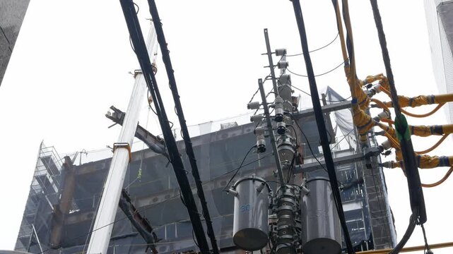 view look up to construction site highrise building builded with steel metal frame trust while crane carrying material to build the tower in daytime