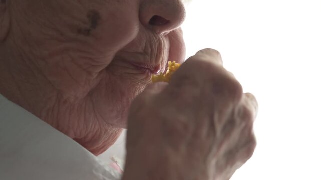 Macro closeup of senior woman mouth chewing soft food