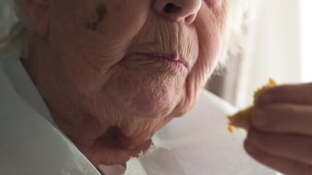 Close up of elderly woman mouth eating soft cake