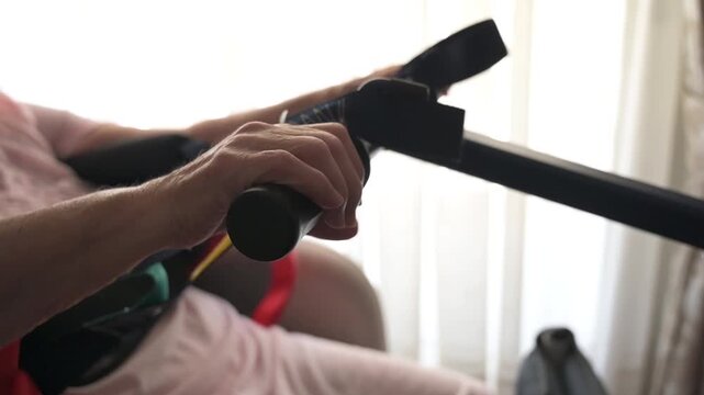 Wrinkled hand of elderly woman gripping standing assistance device during care