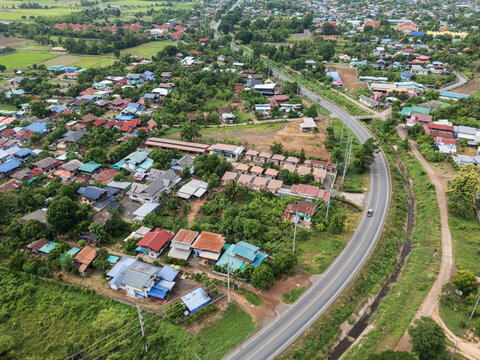 Aerial View of Rural Residential Area with Curving Road and Green Landscape