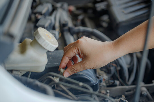 Close up of a hand of woman is checking a liquid coolant pot