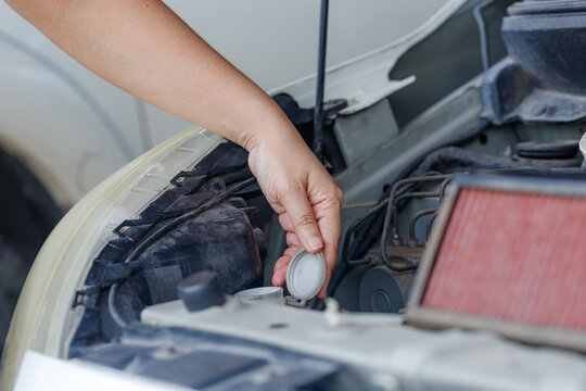 Close up of a hand of woman is checking a liquid coolant pot