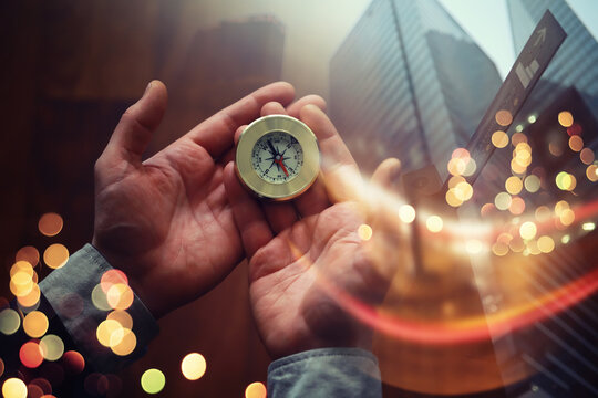 Double exposure businessman with vintage compass in a hand and skyscraper.  concept to make decision or choose direction