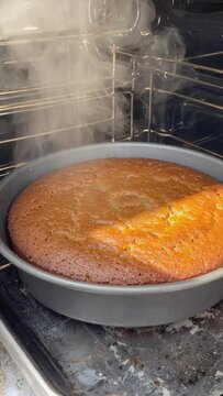 Freshly baked sponge cake steaming in oven