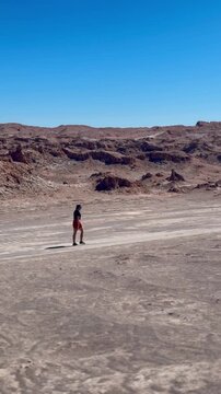 SAN PEDRO DE ATACAMA, CHILE - October 25, 2024: First person view of  walk along a desert path towards the striking multicolored mineral mountains in Valle del Arcoiris (Rainbow Valley), Atacama Deser