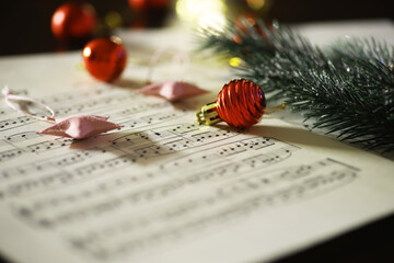 Obraz premium Christmas Sheet Music with Festive Ornaments and Pine Branch Decoration in Soft Focus
