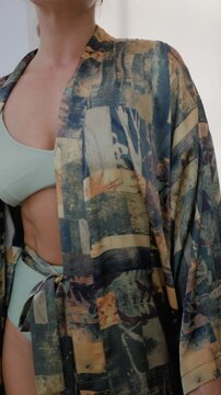 Close up of woman wearing luxury kimono robe over  swimsuit.