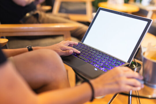 Woman working on a laptop keyboard in a modern co working space.