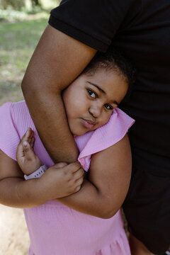 Young girl hugging her fathers arm