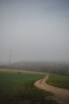 A dirt road in the countryside on a foggy day
