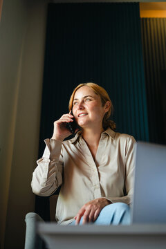 Woman smiling while taking at phone call, copy space