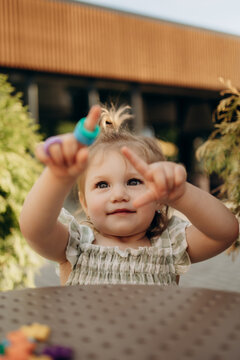 Toddler showing colorful sensory rings during outdoor learning