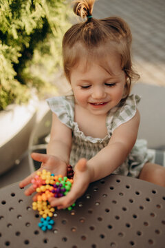 Smiling toddler holding colorful sensory construction pieces