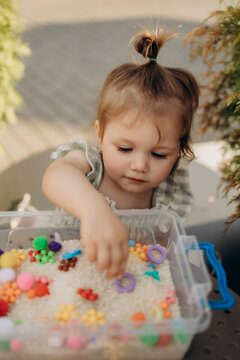 Toddler exploring sensory rice bin during fine motor development