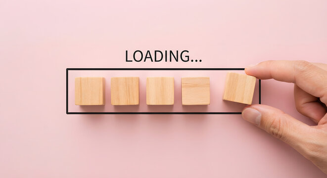 Hand placing last wooden block in loading progress bar frame with LOADING text, task completion concept