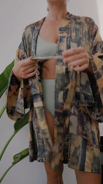 Close up of woman wearing luxury kimono robe over  swimsuit.