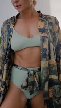 Close up of woman wearing luxury kimono robe over  swimsuit.
